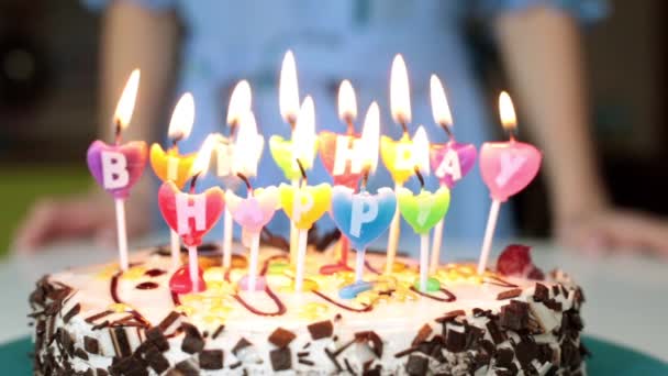 Een vrouw kaarsen op een taart uitblazen. Verjaardag, cake met kaarsen. - Video