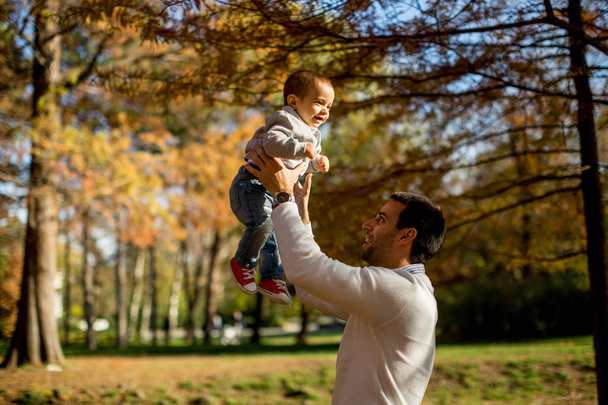 Jovem pai e bebê menino no parque de outono
 - Foto, Imagem