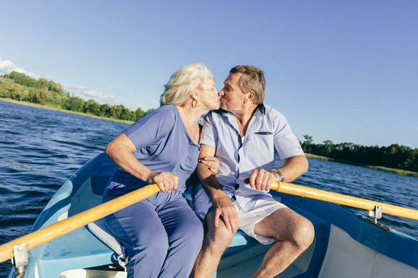Senior couple kissing on a boat. Romantic date of elderly people. - Photo, Image