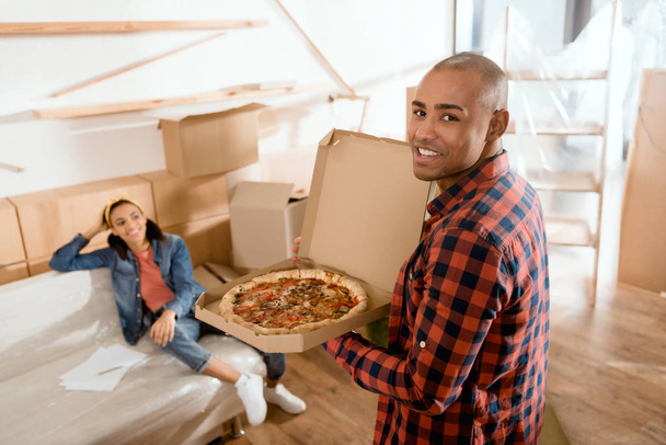 Африканский американский парень приносит пиццу своей девушке
 - Фото, изображение