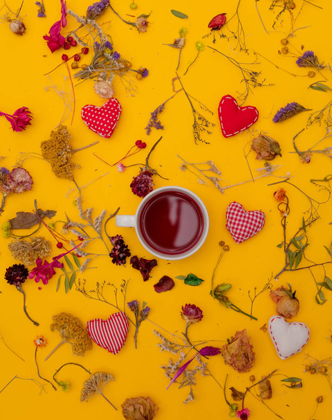 weiße Tasse roter Tee mit Herzformen und Kräutern  - Foto, Bild