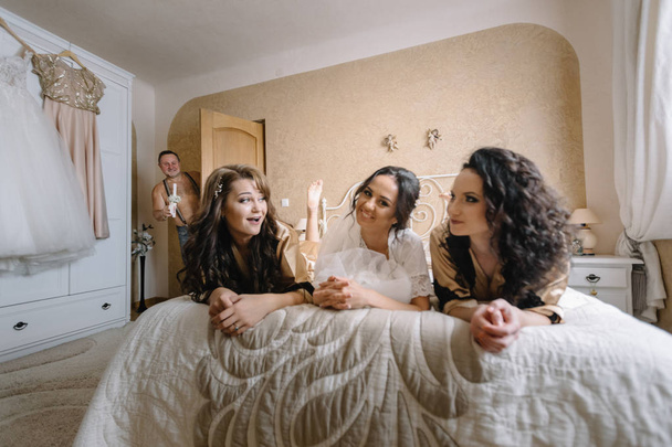 Sexy bride & bridesmaids lying in bed before wedding - Photo, image