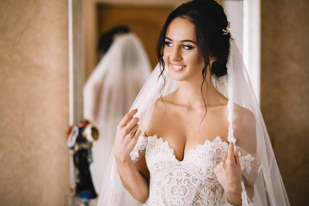 Hermosa novia sexy en vestido blanco posando bajo la cortina
 - Foto, Imagen