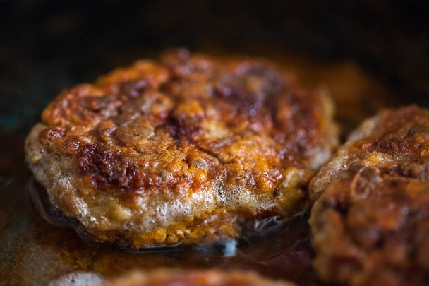 Steaks in a frying pan are roasted on the stove. Fried cutlets - Photo, Image