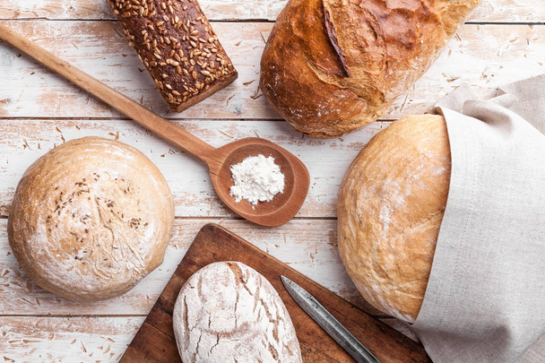 Delicious fresh bread on wooden background - 写真・画像
