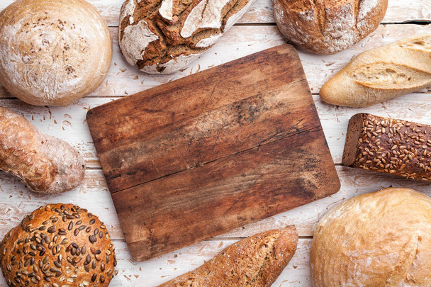 Delicious fresh bread on wooden background - Фото, изображение