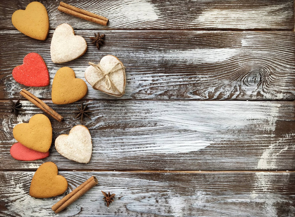 Lovely heart shaped ginger cookies with spice on wooden background. Homemade backing. Cookie on the valentine's day. Flat lay, top view. - Foto, imagen