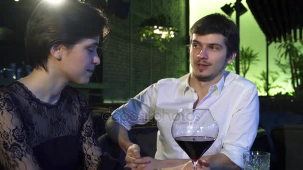 Rakastava pari puhuu iloisesti ollessaan treffeillä ravintolassa
 - Materiaali, video