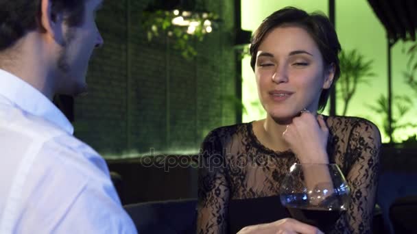 Linda mulher de cabelos escuros bebendo vinho durante o encontro com seu namorado
 - Filmagem, Vídeo