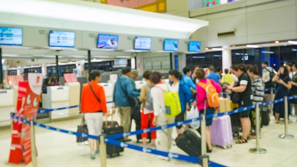 rozostření obrazu cestující a turisty byly fronty pro check-in přepážky letecké společnosti v terminálu letiště odletu - Fotografie, Obrázek