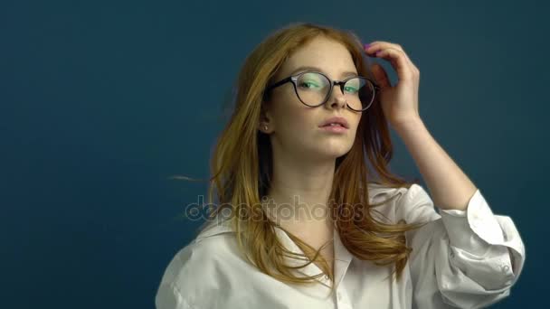 Portrait of student girl on blue background - Πλάνα, βίντεο