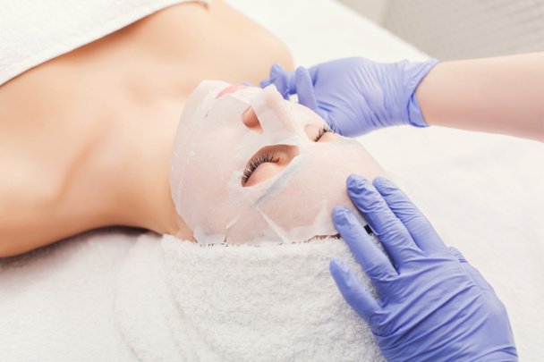 Mujer consigue máscara facial por esteticista en el spa
 - Foto, imagen