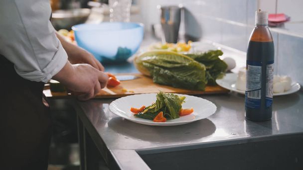 Männerkoch bereitet Salat in Großküche zu - Foto, Bild