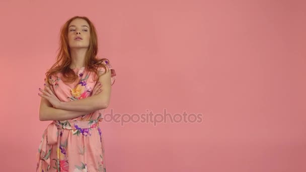 Portrait red-haired fashion model in pink dress on a pink background - 映像、動画