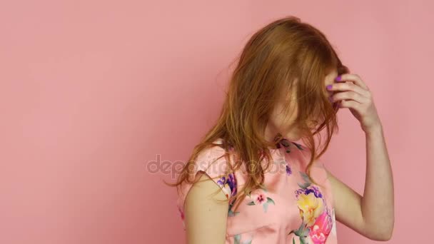 Portrait red-haired fashion model in pink dress on a pink background - Materiał filmowy, wideo