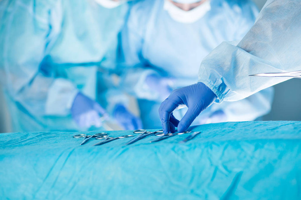 Medical team performing operation. Close up of scrub nurse takin - Foto, Imagen
