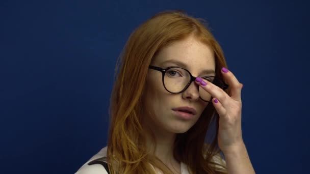 Portrait of student girl on blue background - Πλάνα, βίντεο