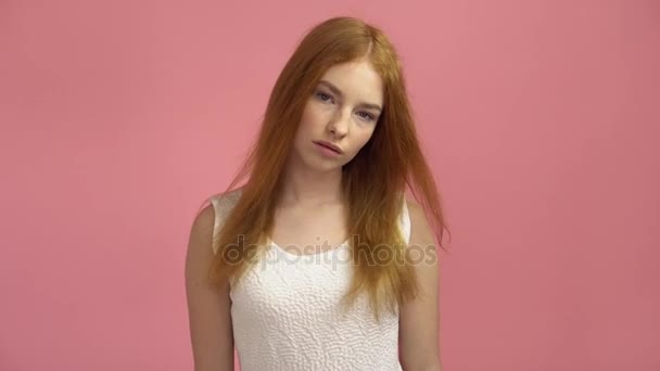 Portrait red-haired fashion model in pink dress on a pink background - Filmati, video