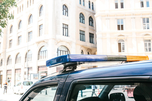 Part of the police car is a siren on the background of the buildings. Conceptual photo of public order protection, representatives of power, protection of the population from crime. Authorities. - Photo, Image