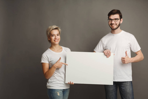 Young couple holding blank white banner - Photo, Image