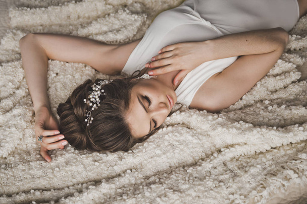 Beautiful brunette lying in bed at the window 8737. - Fotografie, Obrázek
