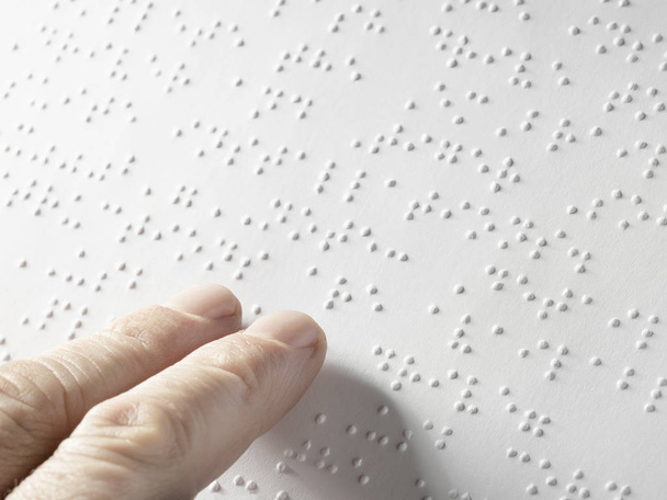 Mão de uma pessoa cega lendo algum texto braille tocando o relevo. Espaço de cópia vazio para Editor
 - Foto, Imagem