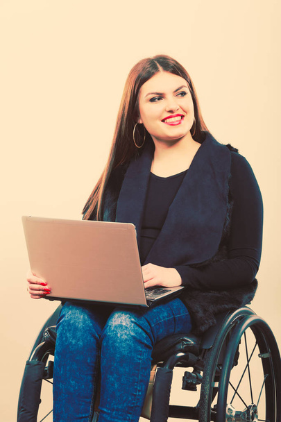 Disabled woman with laptop on wheelchair. - Фото, изображение