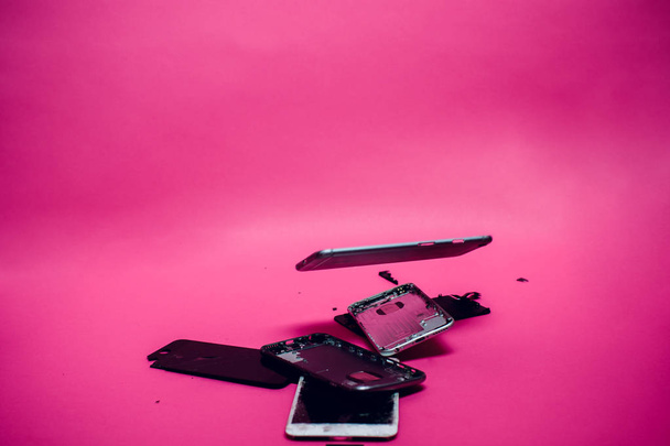 Damaged smartphone Caused by severe shocks. Broken smartphone screen. Phone screen broken in cracks. I like the feel of this, might be something I try to create for my body background pink - Foto, Bild