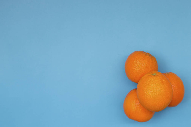 Vista superior do padrão de frutas coloridas de laranjas frescas no fundo azul
 - Foto, Imagem