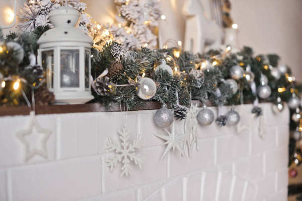 Shelf fireplace decorated with Christmas toys and garlands 9322. - Zdjęcie, obraz