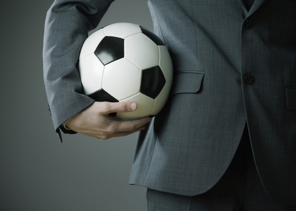 Elegant businessman holding a soccer ball - Fotó, kép