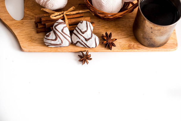 Valentines day concept: Cookies in heart shape symbolize Love decorated with glass of tea. An old tea mug, pink flowers, gingerbread cookies on a white background. - Fotografie, Obrázek