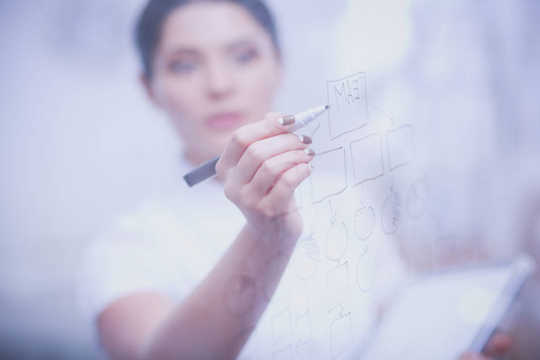 junge Frau zeichnet auf Whiteboard mit weißem Copyspace. junge Frau - Foto, Bild