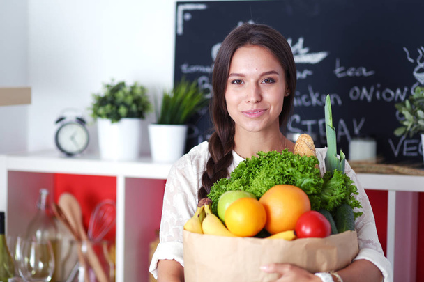 Young woman holding grocery shopping bag with vegetables. Young woman - Photo, Image