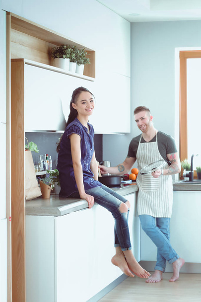 Couple cooking together in their kitchen at home - Foto, Imagem