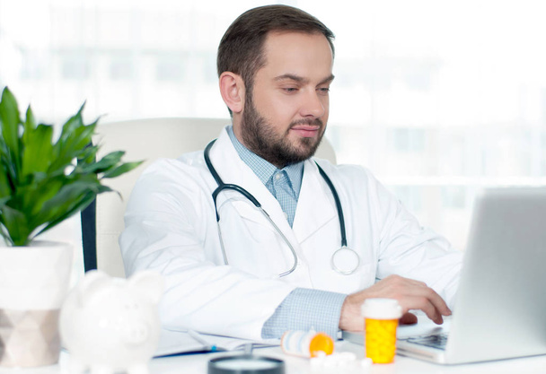 Medicine concept. Doctor sitting at the desk in hospital - Photo, Image