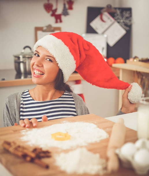 Happy young woman smiling happy having fun with Christmas preparations wearing Santa hat - Φωτογραφία, εικόνα