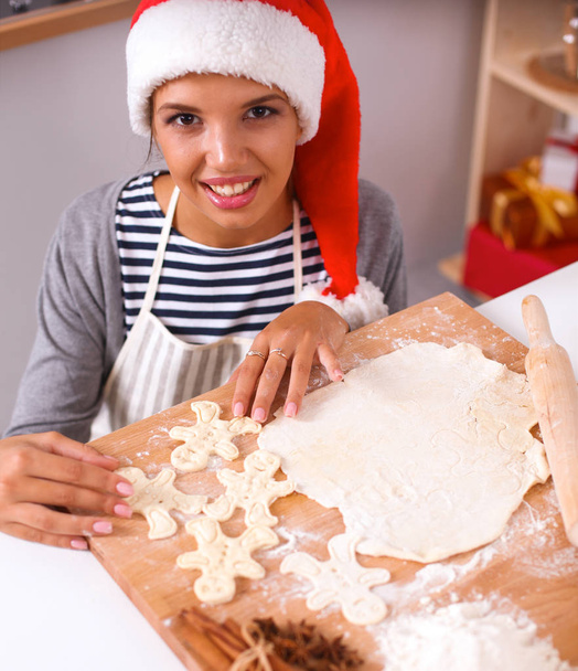Happy young woman smiling happy having fun with Christmas preparations wearing Santa hat - Foto, imagen