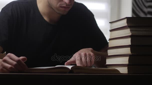 Mann aus nächster Nähe liest Buch in der Bibliothek - Filmmaterial, Video