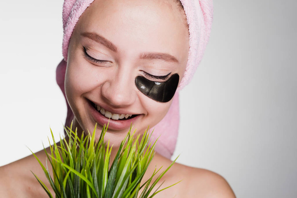 happy smiling girl with pink towel on her head holds a green plant - Fotoğraf, Görsel