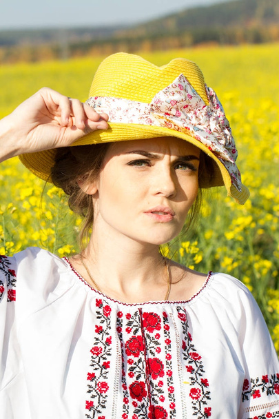 Emotional young girl in a hat among wildflowers - 写真・画像