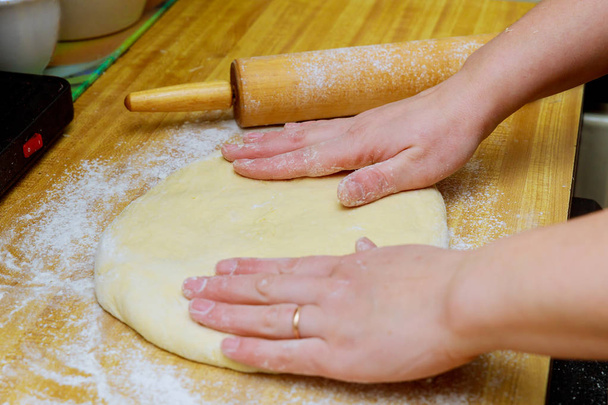 Raw pizza dough with ingredients on wooden dough on the table - Foto, Imagen