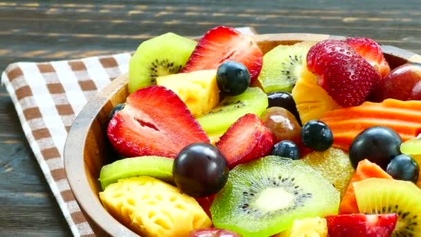 geassorteerde rijpe vruchten en bessen in houten kom op rustieke tafel  - Video