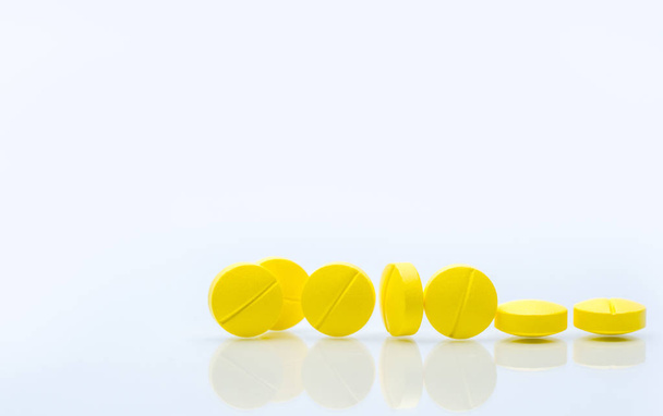 Žluté tablety prášky izolovaných na bílém pozadí s kopie prostoru. Hromadu medicíny. - Fotografie, Obrázek