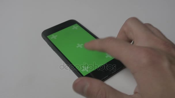 Στενή επάνω ο άνθρωπος χρησιμοποιώντας Smartphone με πράσινη οθόνη Chroma κλειδί αφής σε φόντο λευκό γραφείο - Πλάνα, βίντεο