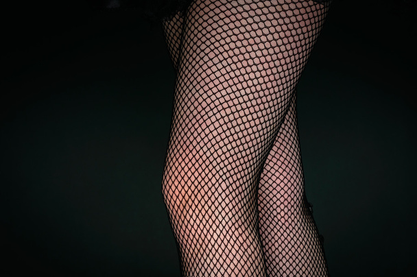 Legs of a youn woman against dark background - Fotó, kép