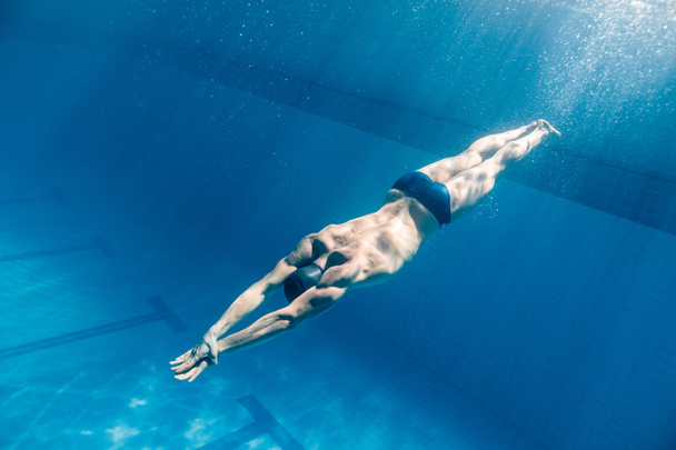 underwater picture of male swimmer swimming i swimming pool - Fotó, kép