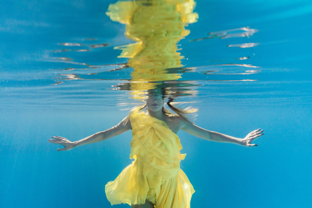 partial view of woman in dress swimming underwater - Foto, Bild