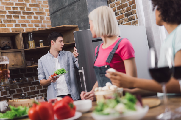 человек берет овощи из холодильника на кухне
 - Фото, изображение