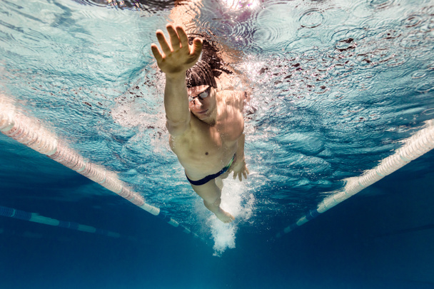 photo sous-marine de jeune nageur en lunettes faisant de l'exercice dans la piscine
 - Photo, image